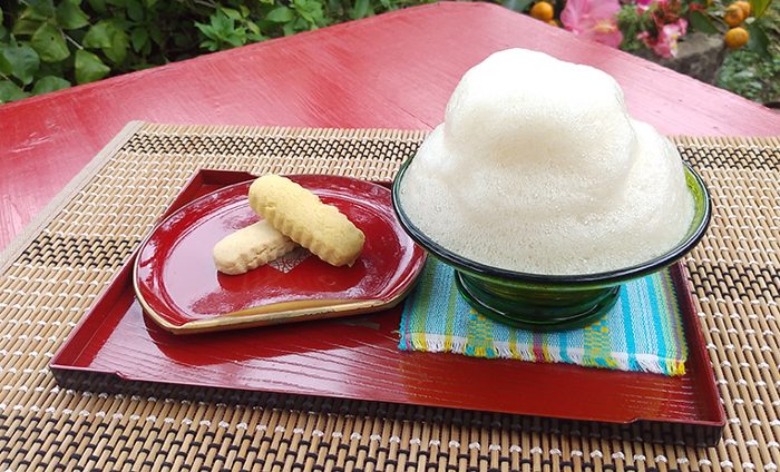 ブクブクー茶：碗上堆著白色泡沫，旁邊是琉球茶點